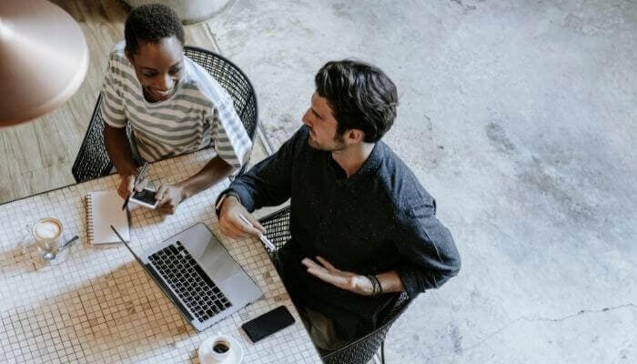 email list metrics being discussed by two people sitting a table. 