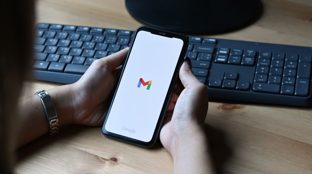 Two hands holding phone with window showing the Gmail app to illustrate news on Google email verification protocol and what it means for email marketing